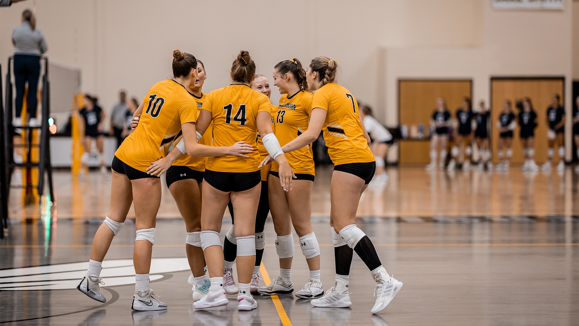 The volleyball team huddling after a point.