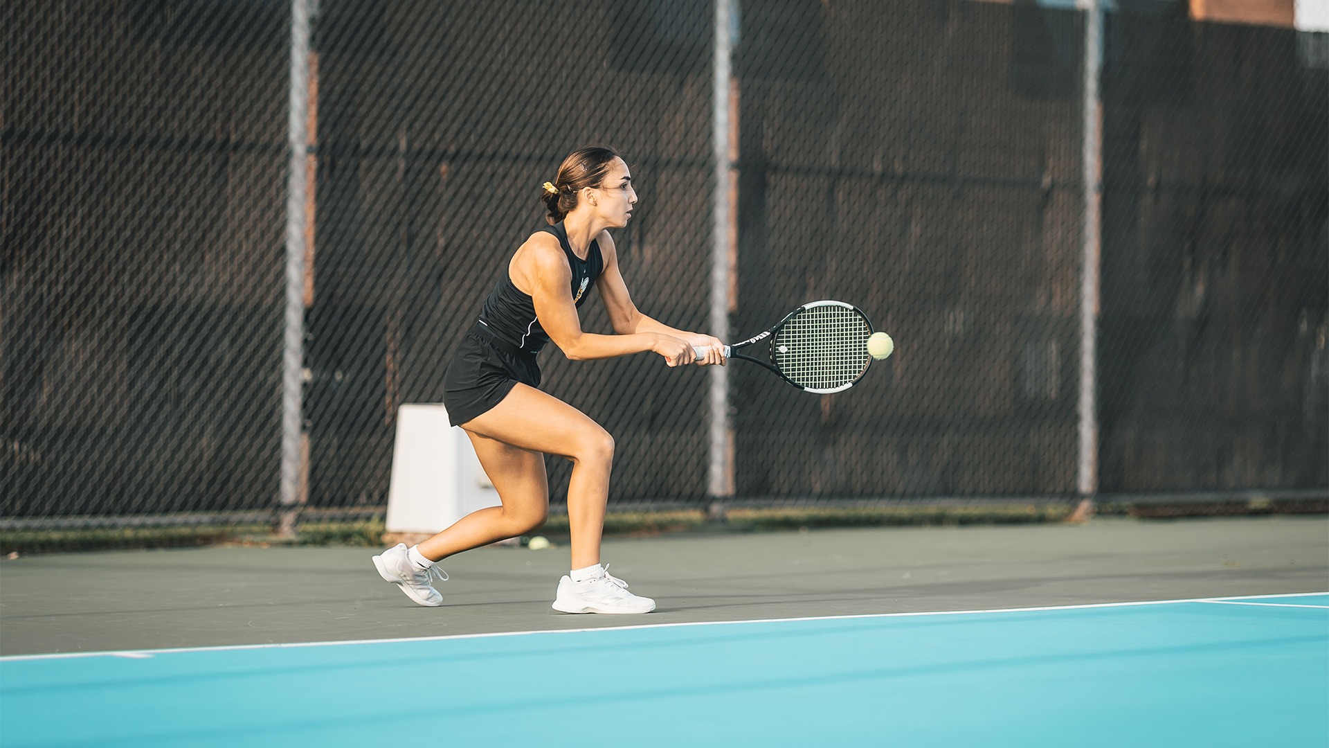Elif Oezen making contact with a backhand shot.
