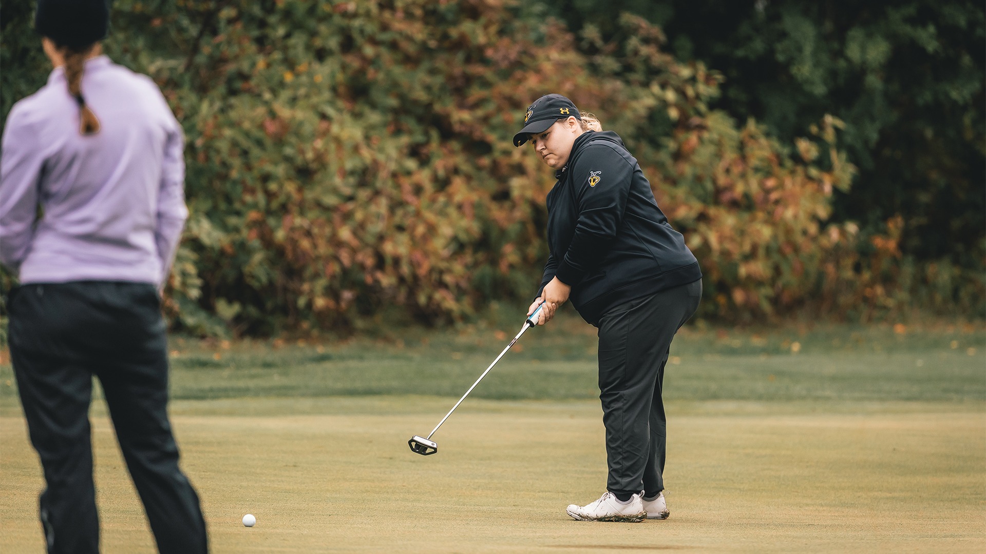 Allie Maschke watching her putt roll towards the cup.