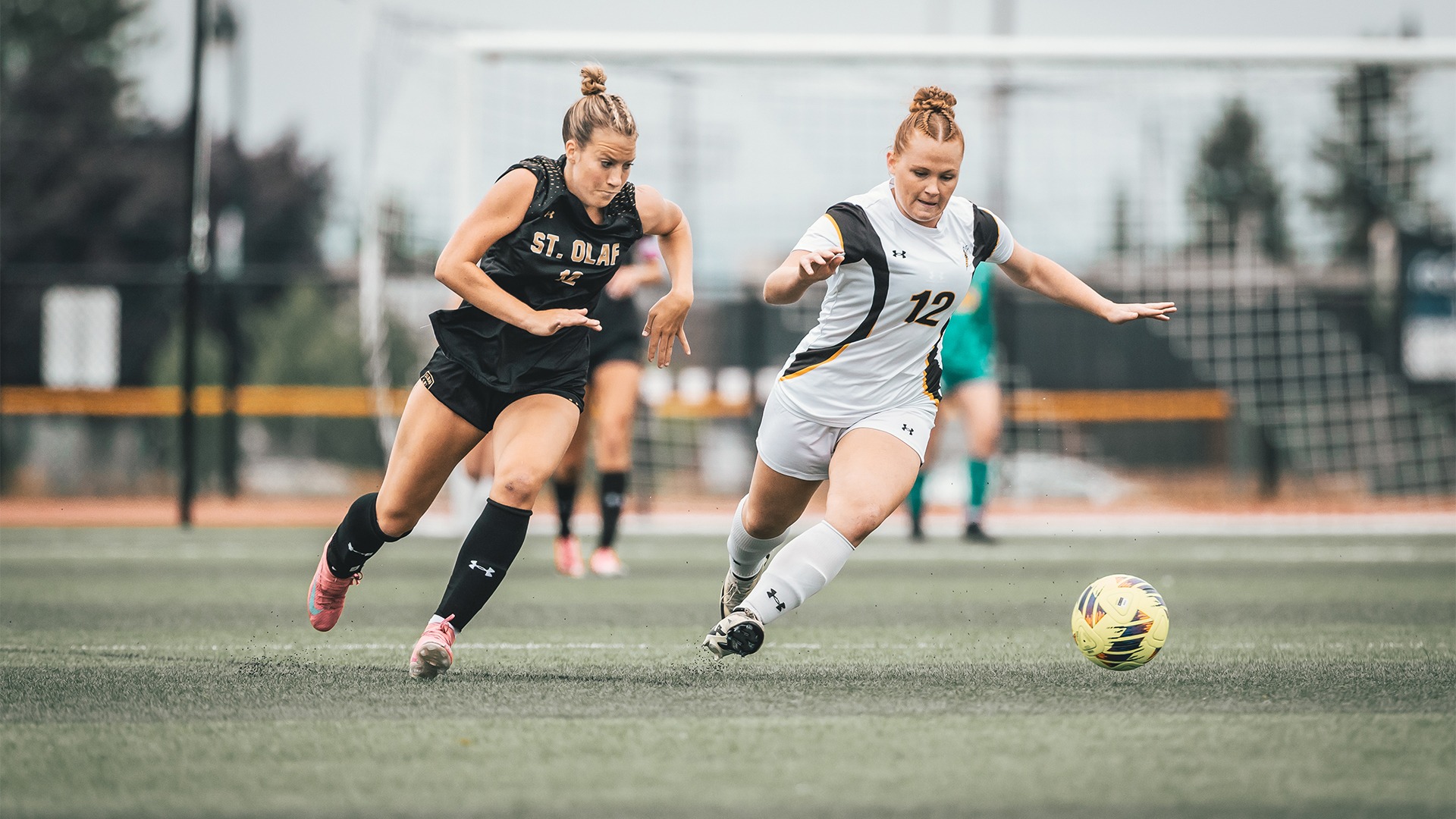 Emma Wright chasing the ball ahead of a St. Olaf defender.