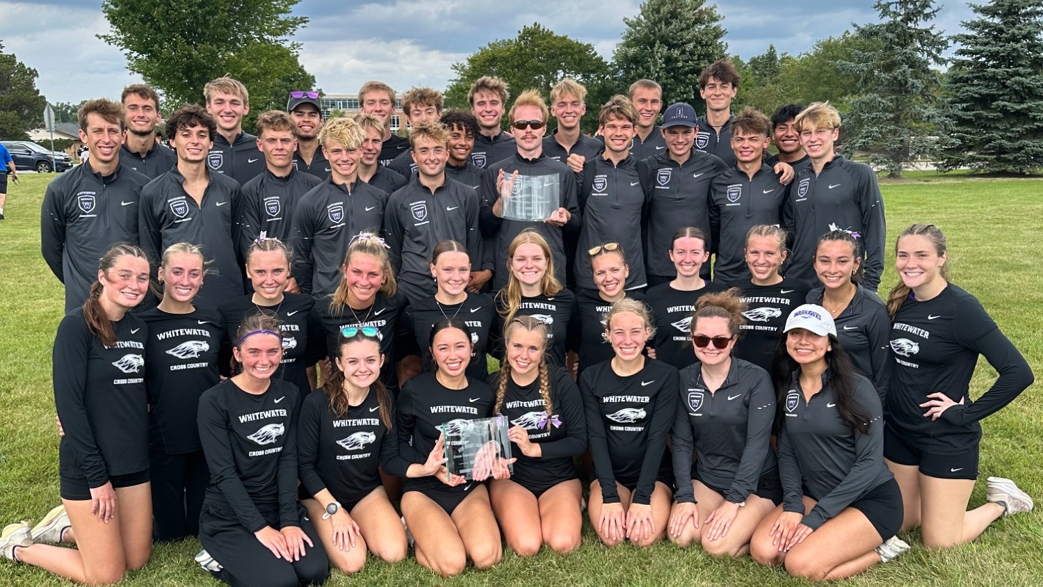 Cross country teams pose with first place plaques