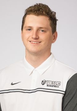 Smiling Caucasian man in a white polo shirt that says 