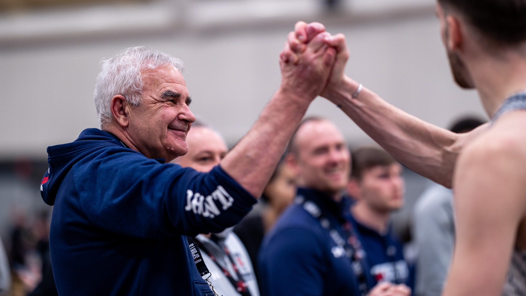 Carl Georgevski high fives a track and field athlete