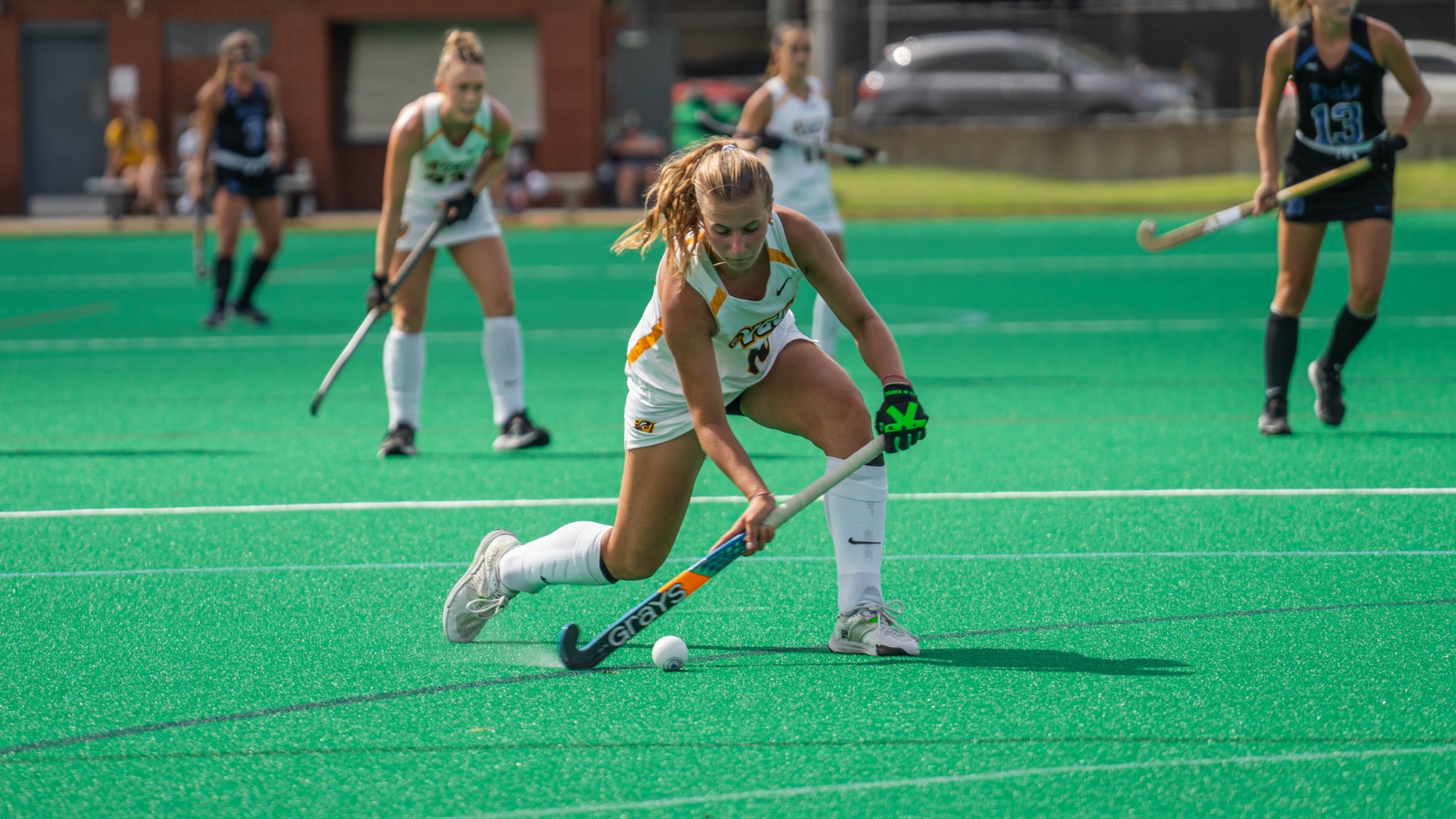 Lina Berhmann of VCU Field Hockey wearing a white #10 jersey plays a pass against Duke