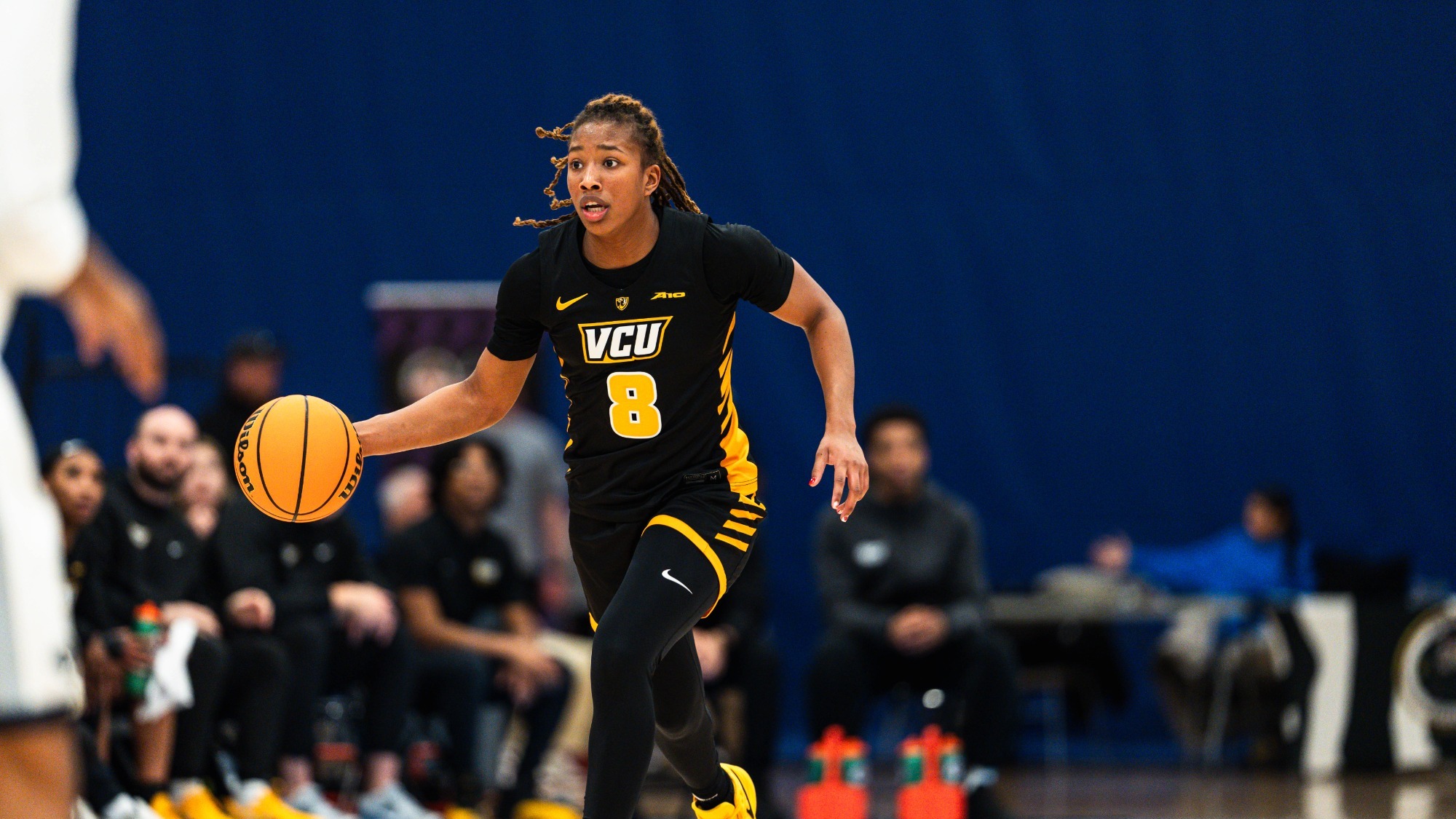 Daija Preston of VCU wearing a black #8 uniform dribbles the ball up the floor in a game against Penn State