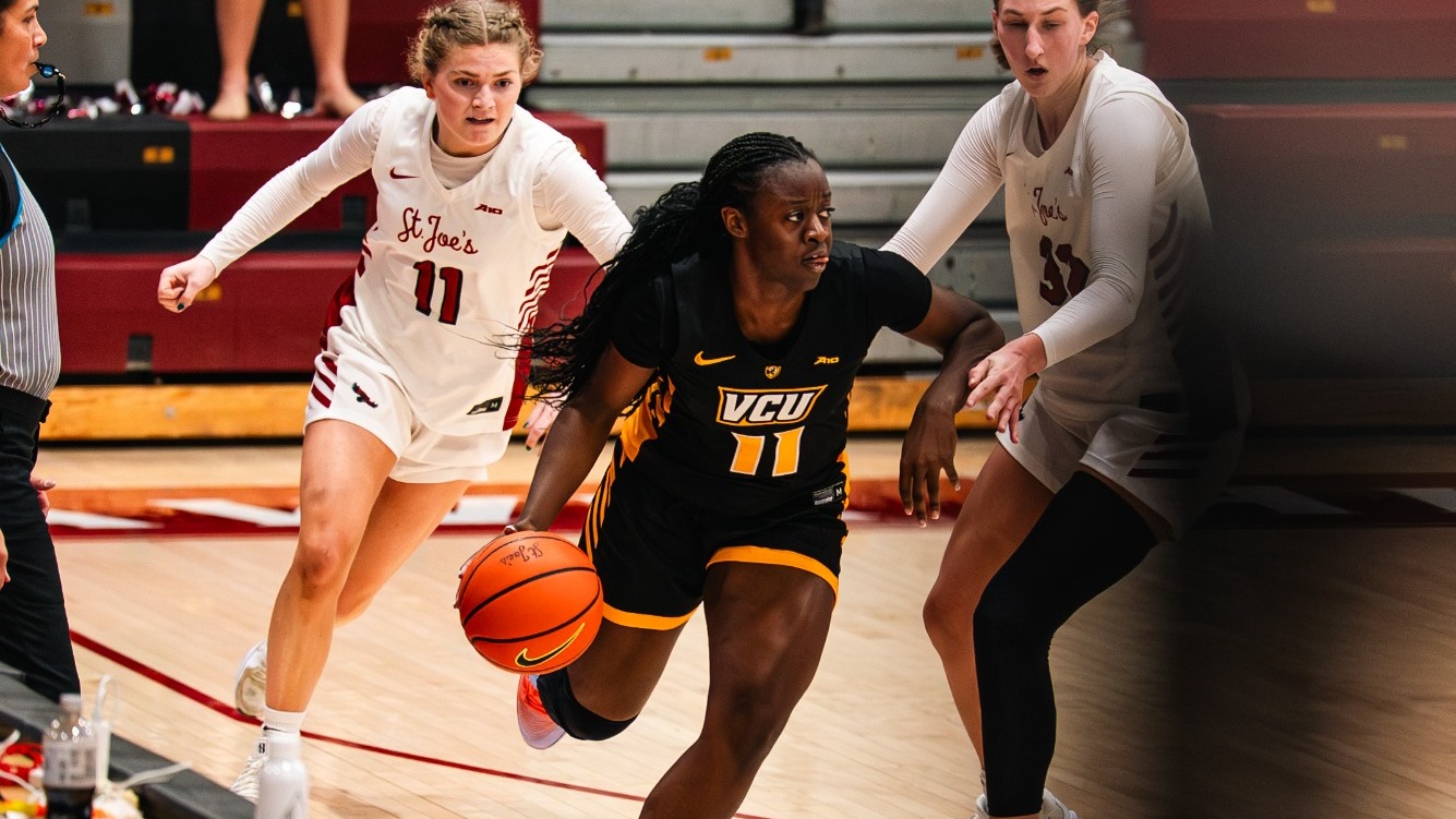Mary-Anna Asare of VCU wearing a black #11 jersey dribbles up the floor in a game against Saint Joseph's