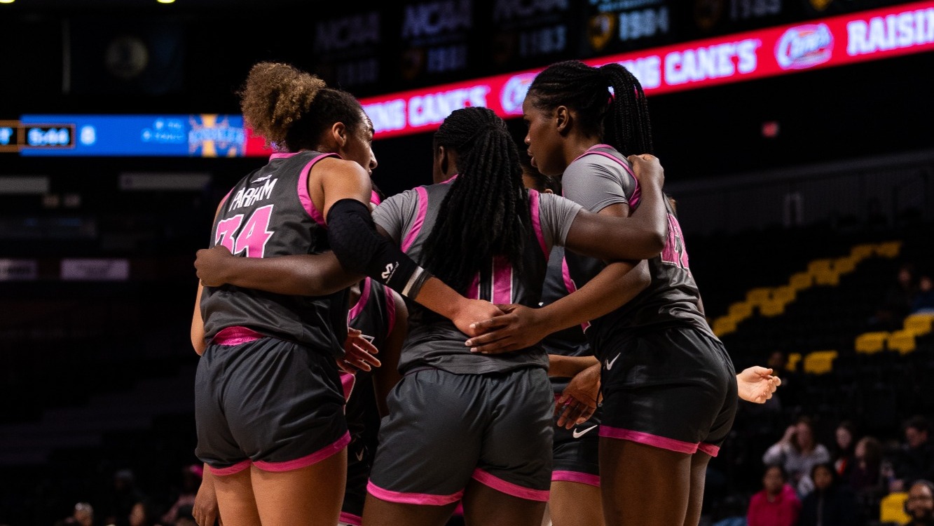 The VCU Women's Basketball team huddles together after a play wearing their pink and gray uniforms for their Play4Kay game during the 2023-24 season
