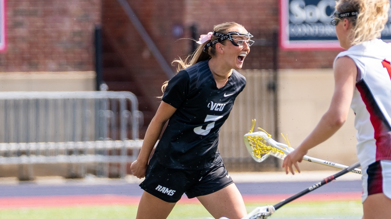 Ashley Karn of VCU Lacrosse wearing a black #3 jersey screams in celebration after scoring a goal against Davidson