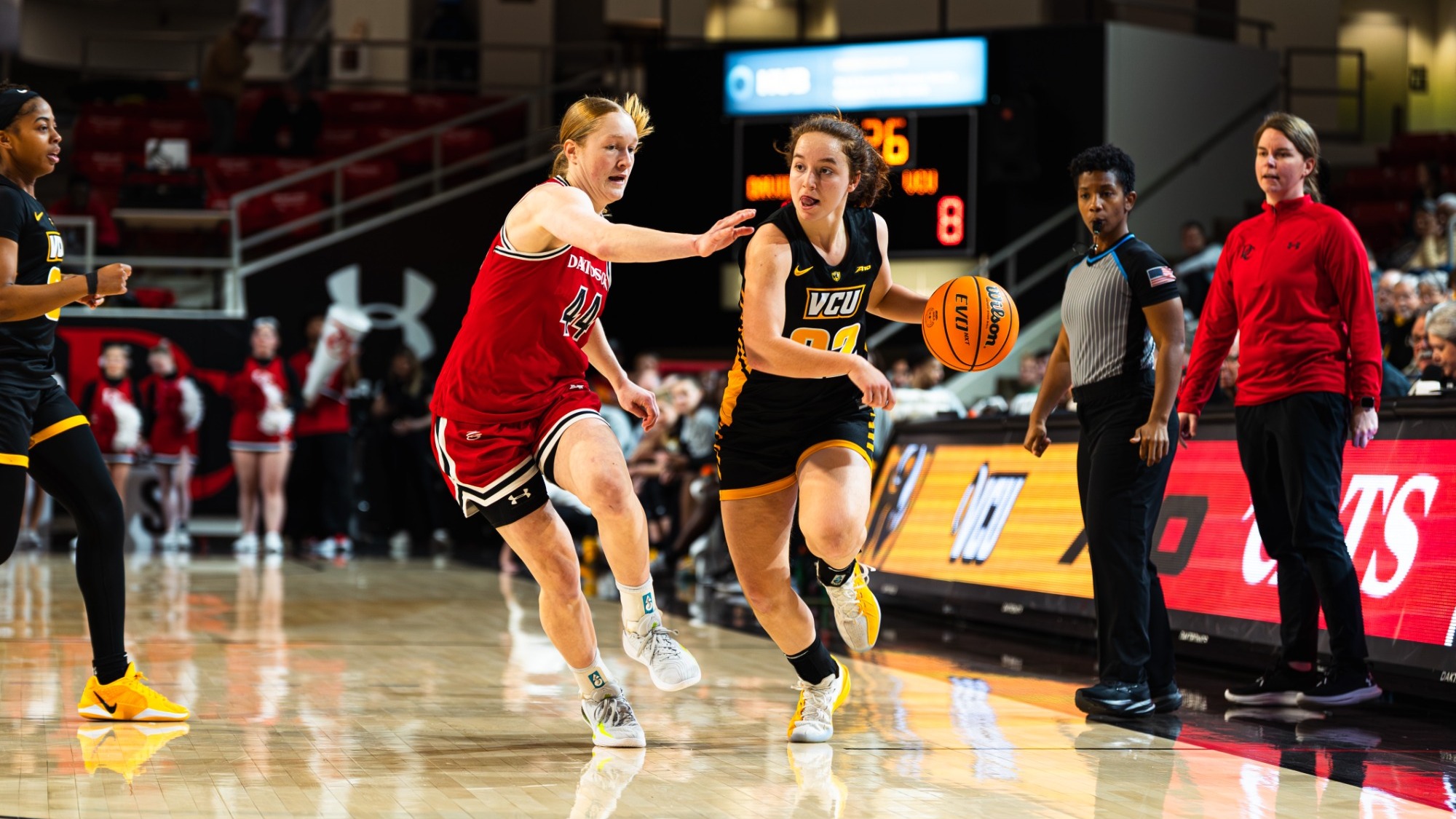 Laia Crespin of VCU wearing a black 22 jersey dribbles the ball while guarded by a Davidson defender