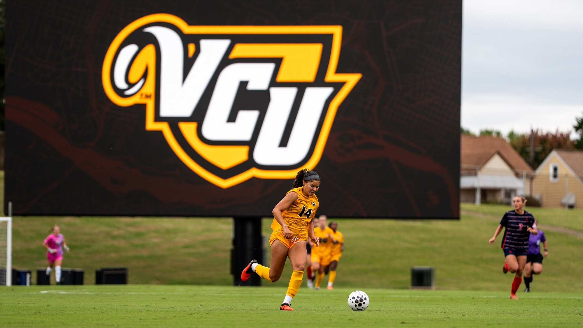 Jazmin Jackson dribbles in front of VCU logo at City Stadium vs. Duquesne