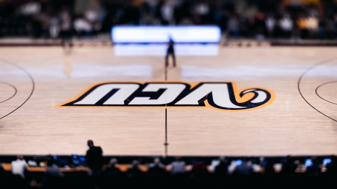 A photo of the VCU Siegel Center Floor with the VCU logo in the middle and a blurred background around it