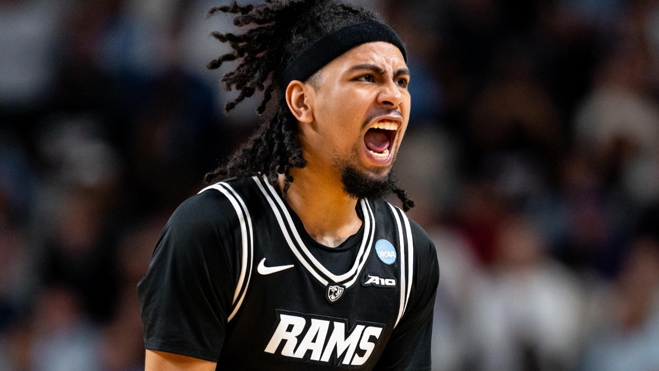 Terrence Hill Jr. of VCU wearing a black jersey with Rams across the front screams in a NCAA Tournament First Round game against UNC