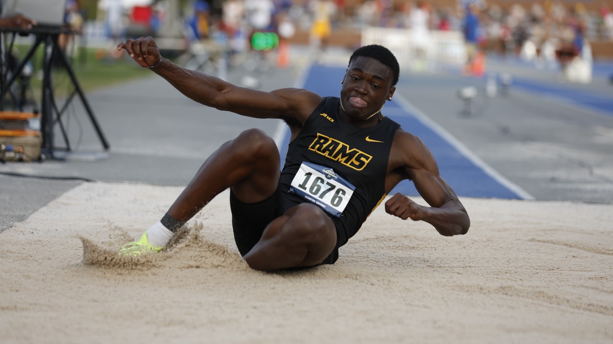 Isaiah-Taji Kargbo-Owens wearing a black uniform lands in the sand pit of the triple jump at the NCAA East Region First Round