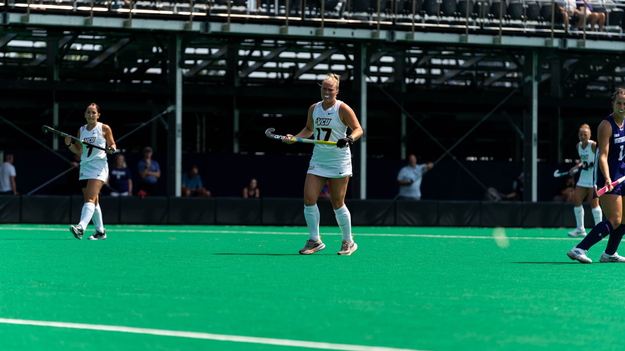 Carley Deaver of VCU Field Hockey wears a white #17 jersey holding her stick in a game against Northwestern 