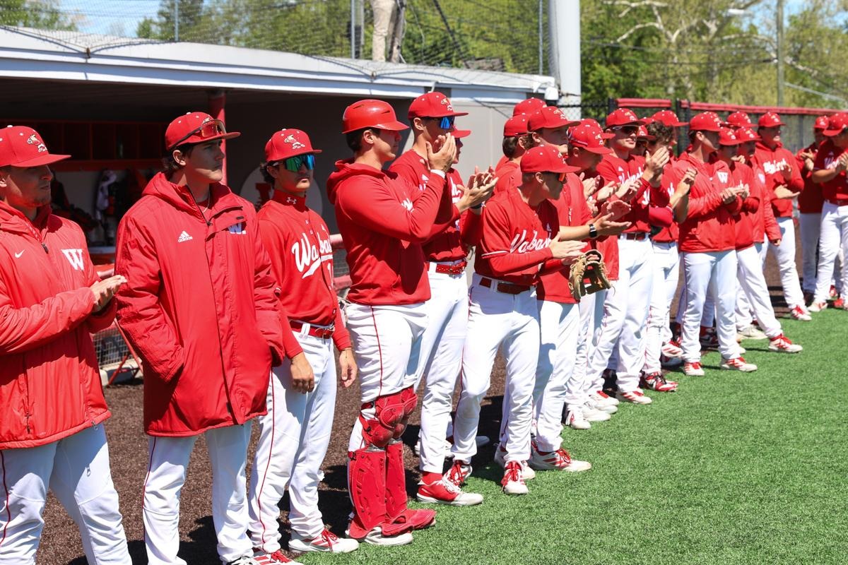Members of the 2026 Wabash College baseball gather in front of the dugout.