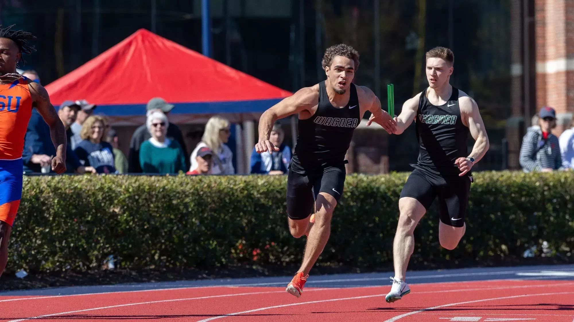 Alex Taddeo hands a baton off to Julio Tatis at the Fred Hardy Invitational 
