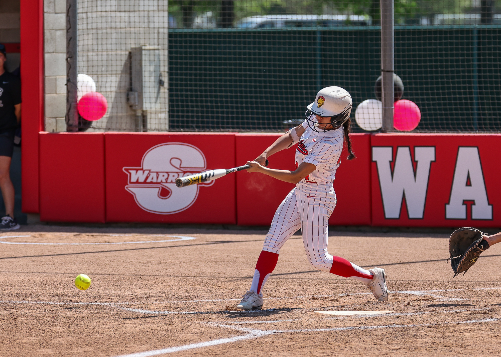 Malia Babasa swings, her bat just making contact with the ball.