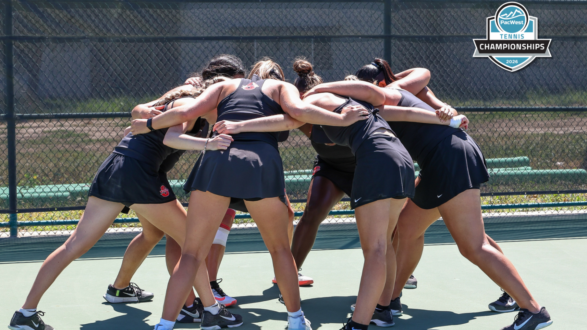 Stan State women’s tennis team huddles together on the court before their final match of the season at the PacWest Championships.