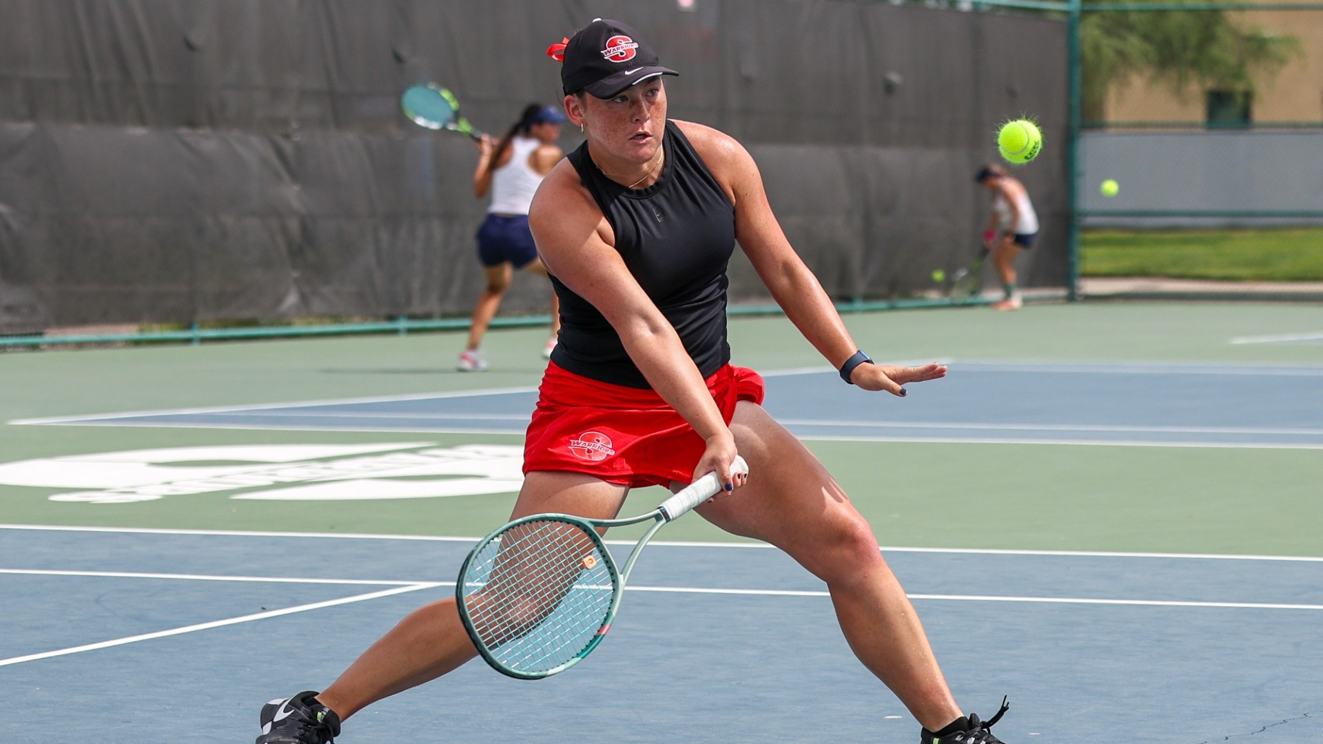 Emma Yu approaches a tennis ball, about to hit it over the net.