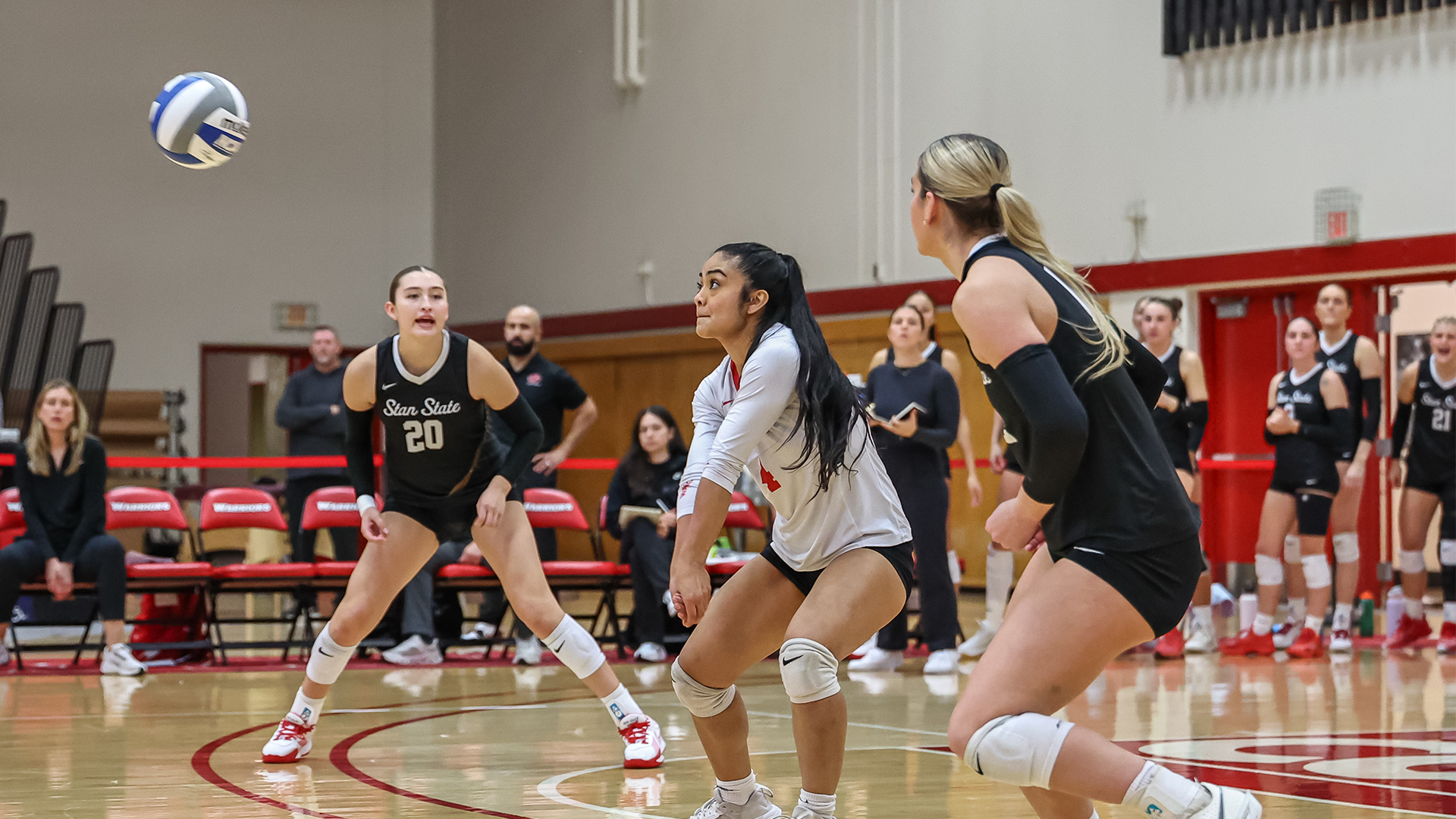 Action shot of Leah Mendoza with teammates Lauren Gonzales and Emily Meyer