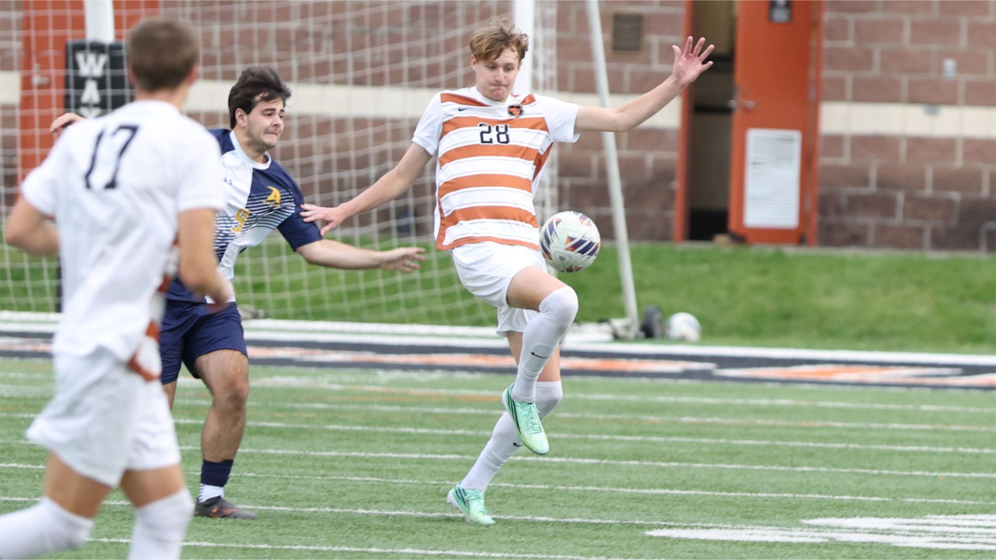 Junior Noah Biser plays a ball off his knee while evading a defender