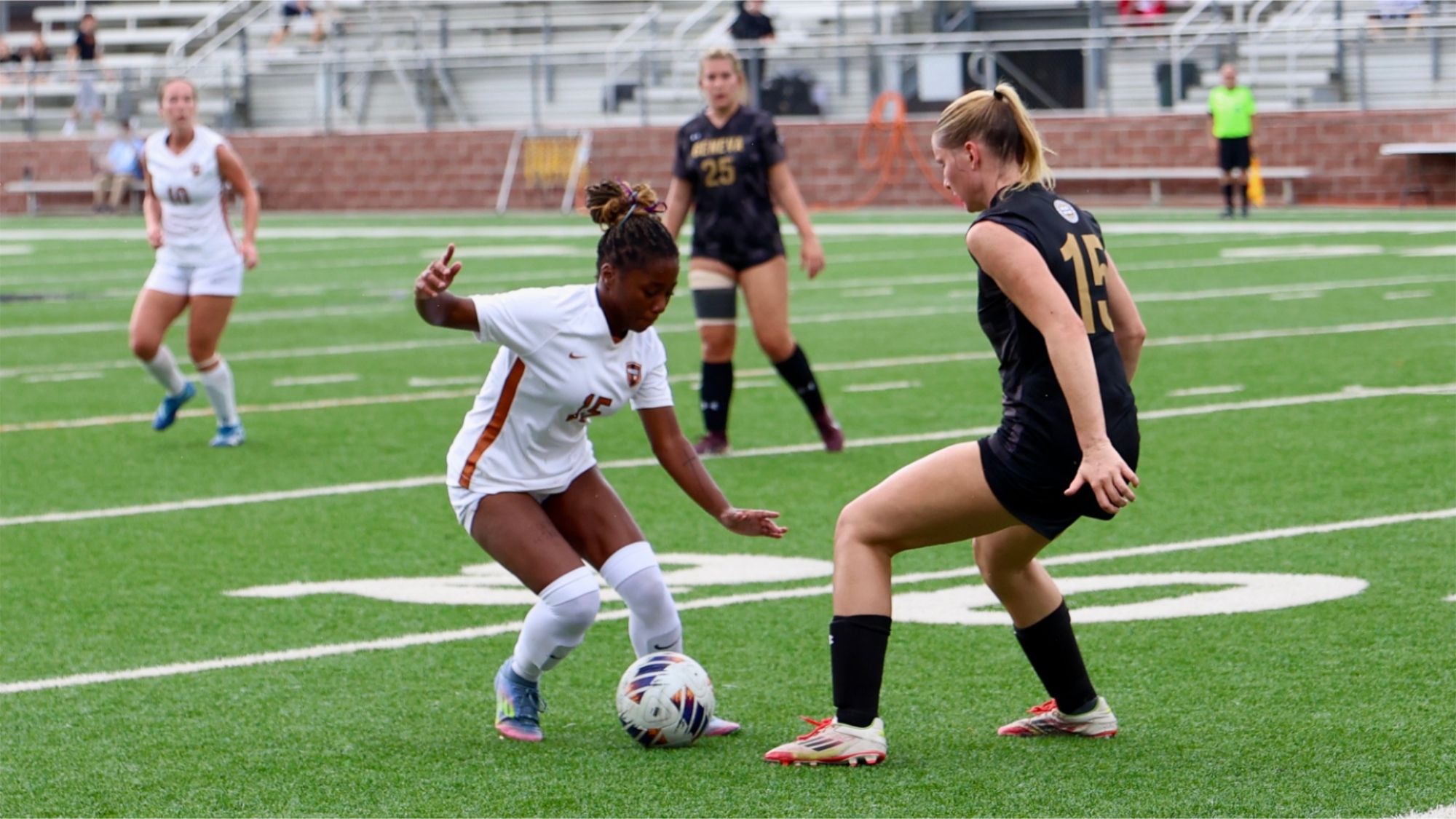 Miracle Hershey works to dribble the soccer ball around a defender
