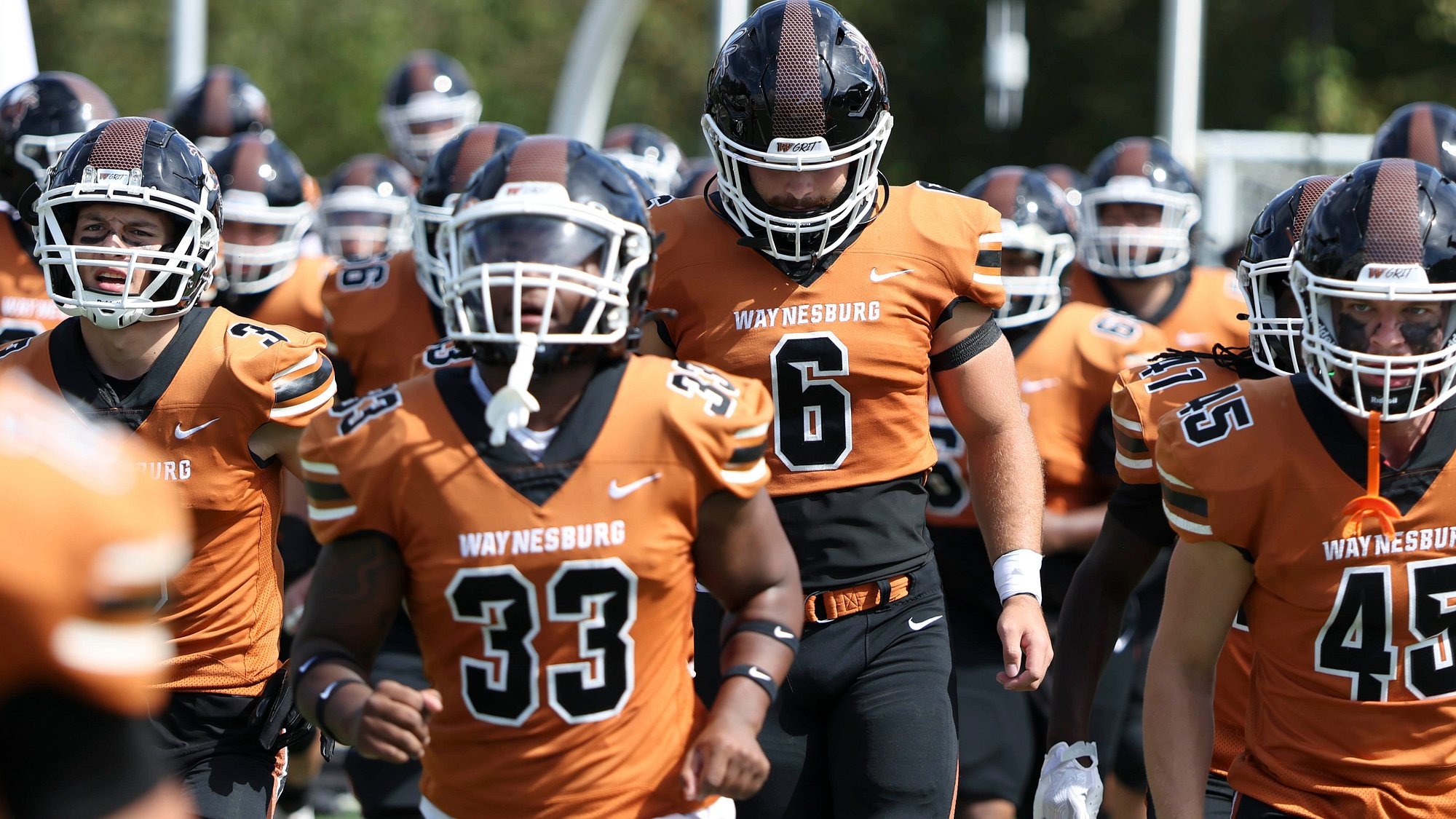 Members of the Yellow Jacket football team jog out before a game starts