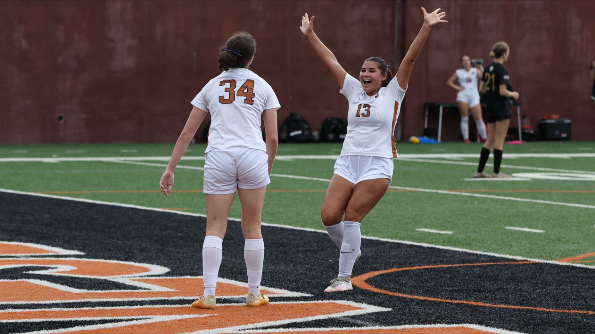 Amanda Pepe smiles and throws her hands up in the air as she celebrates with teammate Julz Mohrbacher
