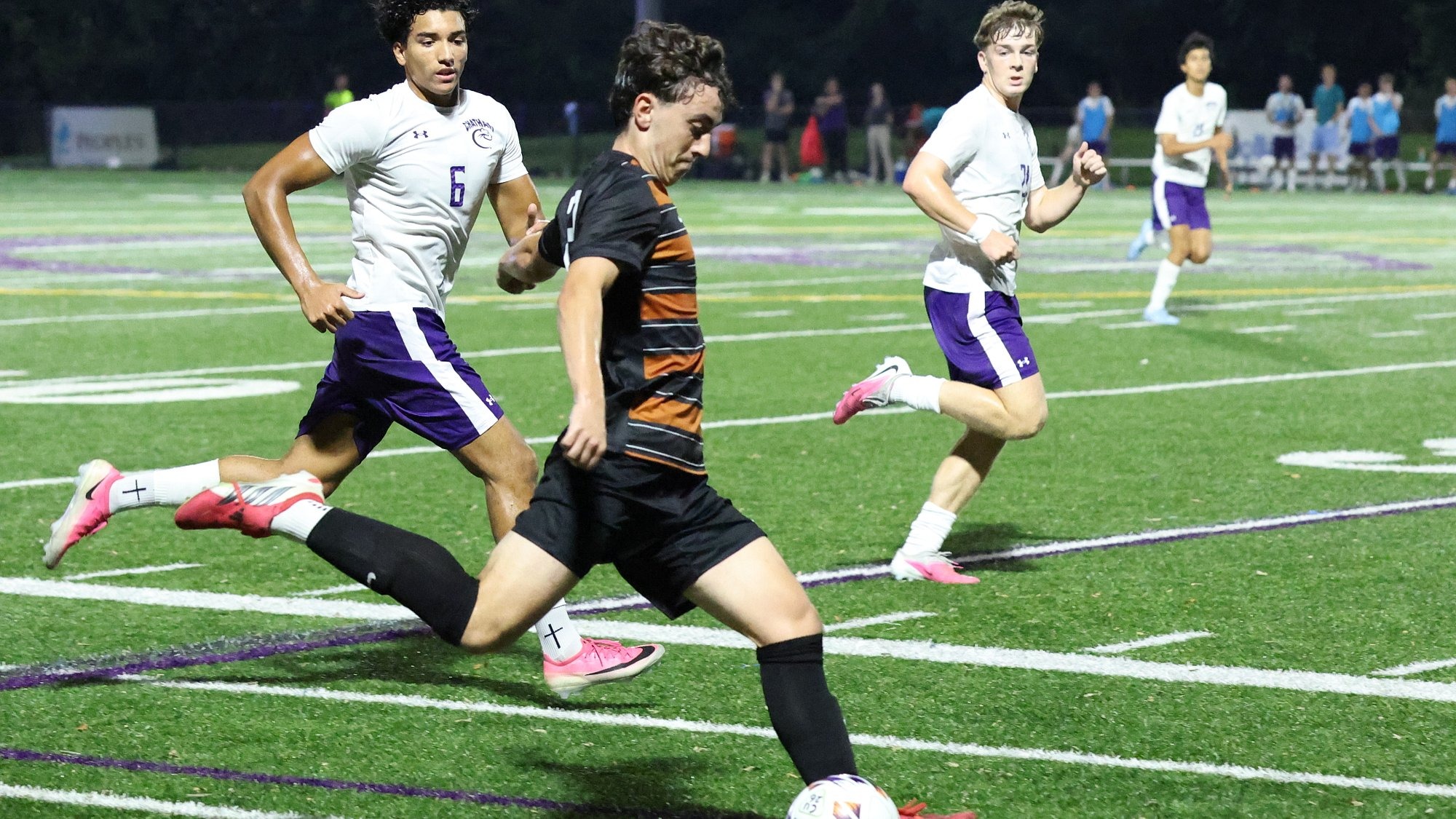 A Waynesburg men's soccer player prepares to drive a kick as several opposing players look on