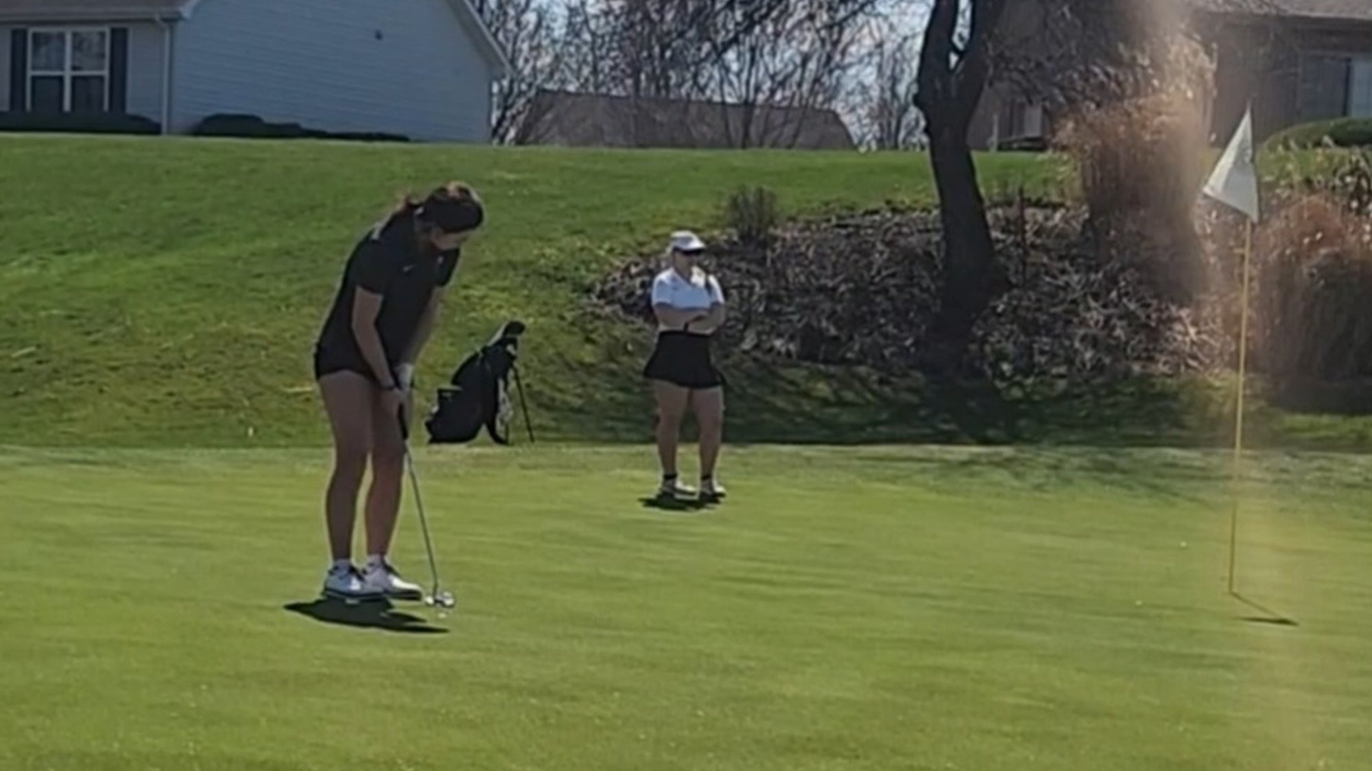 Member of the WU women's golf team lines up a putt