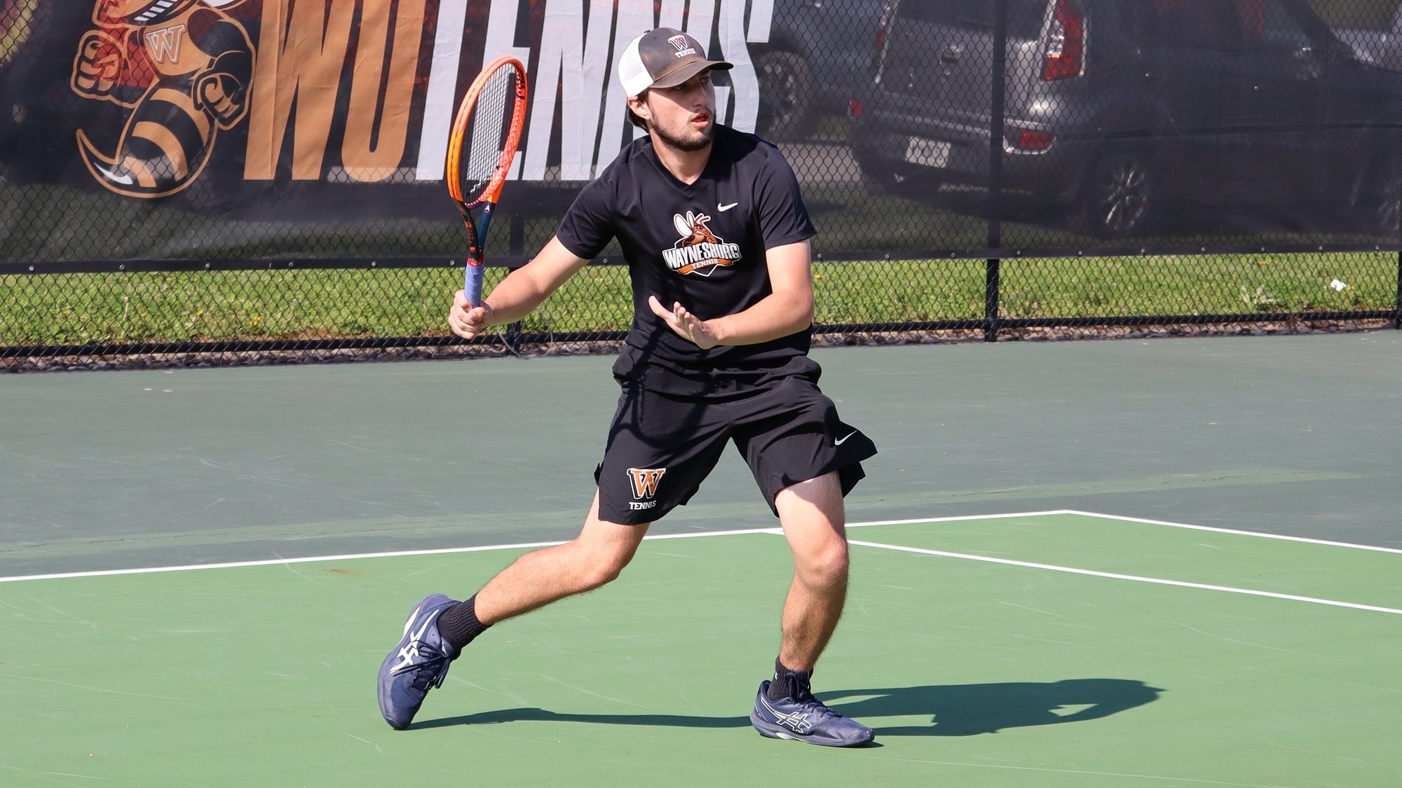 Thomas Torcaso volleys for Waynesburg men's tennis