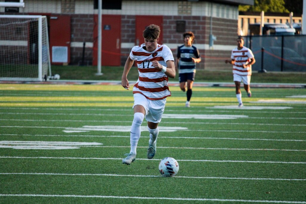 John Engle sprinting up the field with the ball ahead of him. 