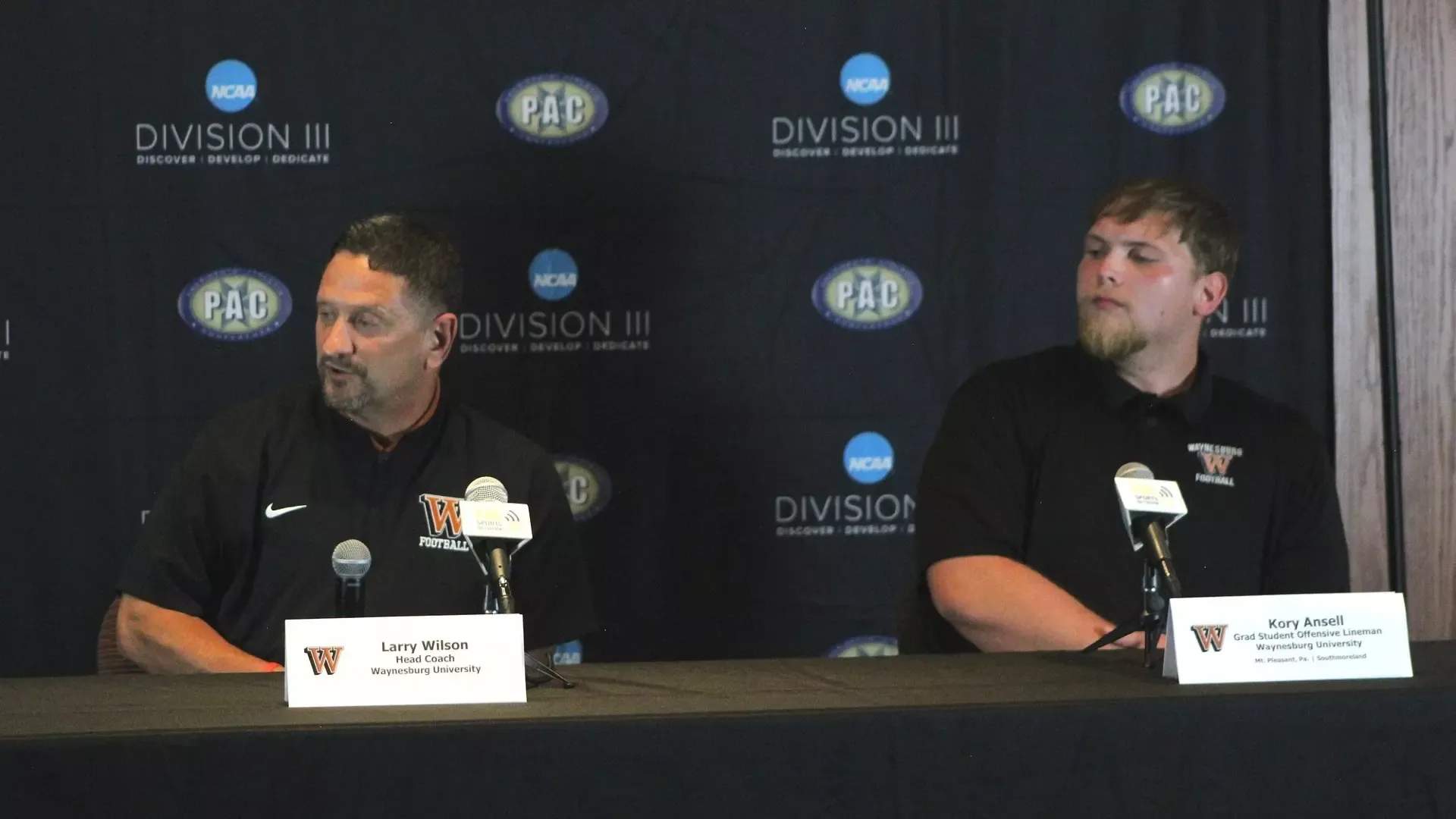 Head coach Larry Wilson and graduate student Kory Ansell address the crowd at PAC football media day from the interview table