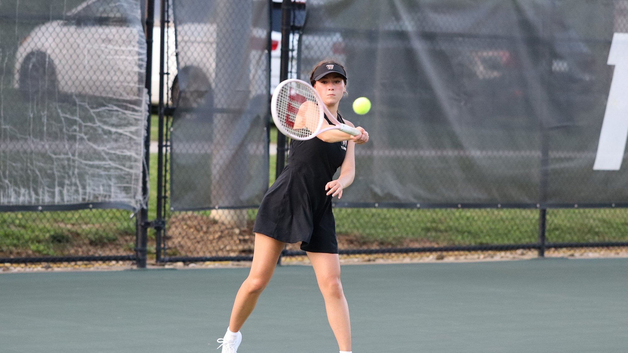 Waynesburg junior Julia Umshares strikes a forehand return during a match