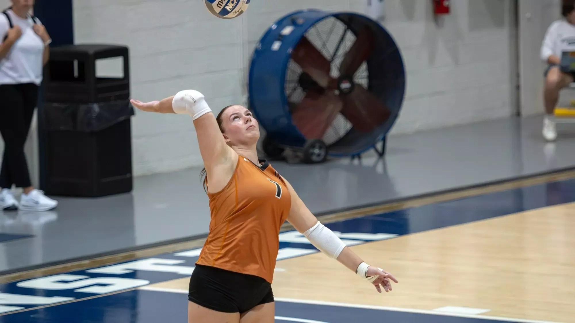 Waynesburg's Bostyn Guinn serves on the court at Westminster College