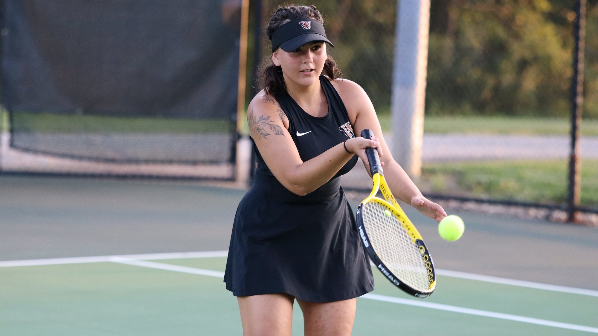 Karly Starcher hits an underhand forehan on the tennis court