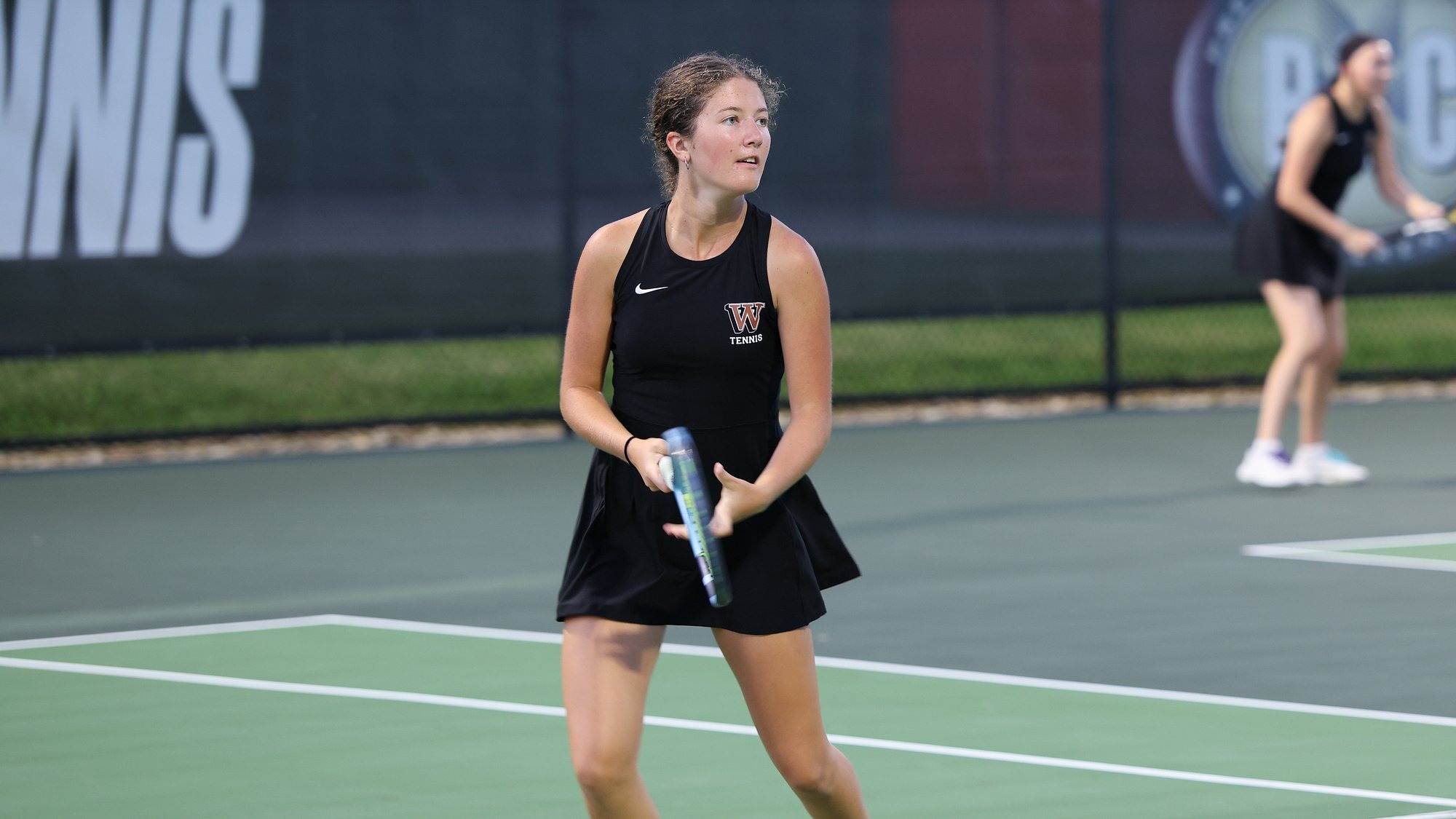 Taylor Stephens prepares to return a volley on the Waynesburg tennis courts with Julia Luzar standing in the background