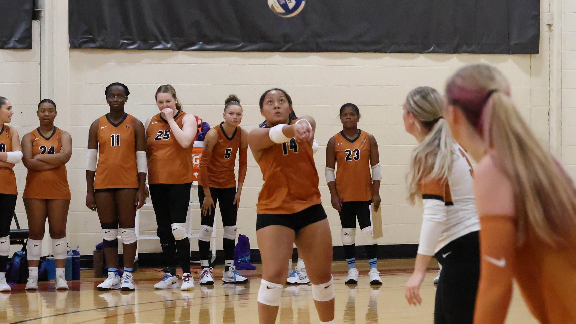 Waynesburg's Shamere Waugh bumps a ball up in the air as her teammates watch on