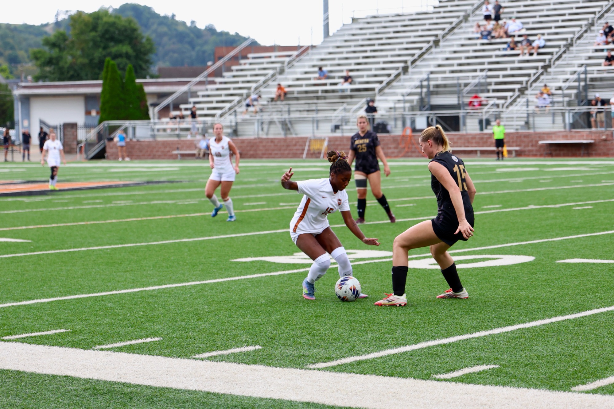 Miracle Hershey attempting to dribble past a defender. 