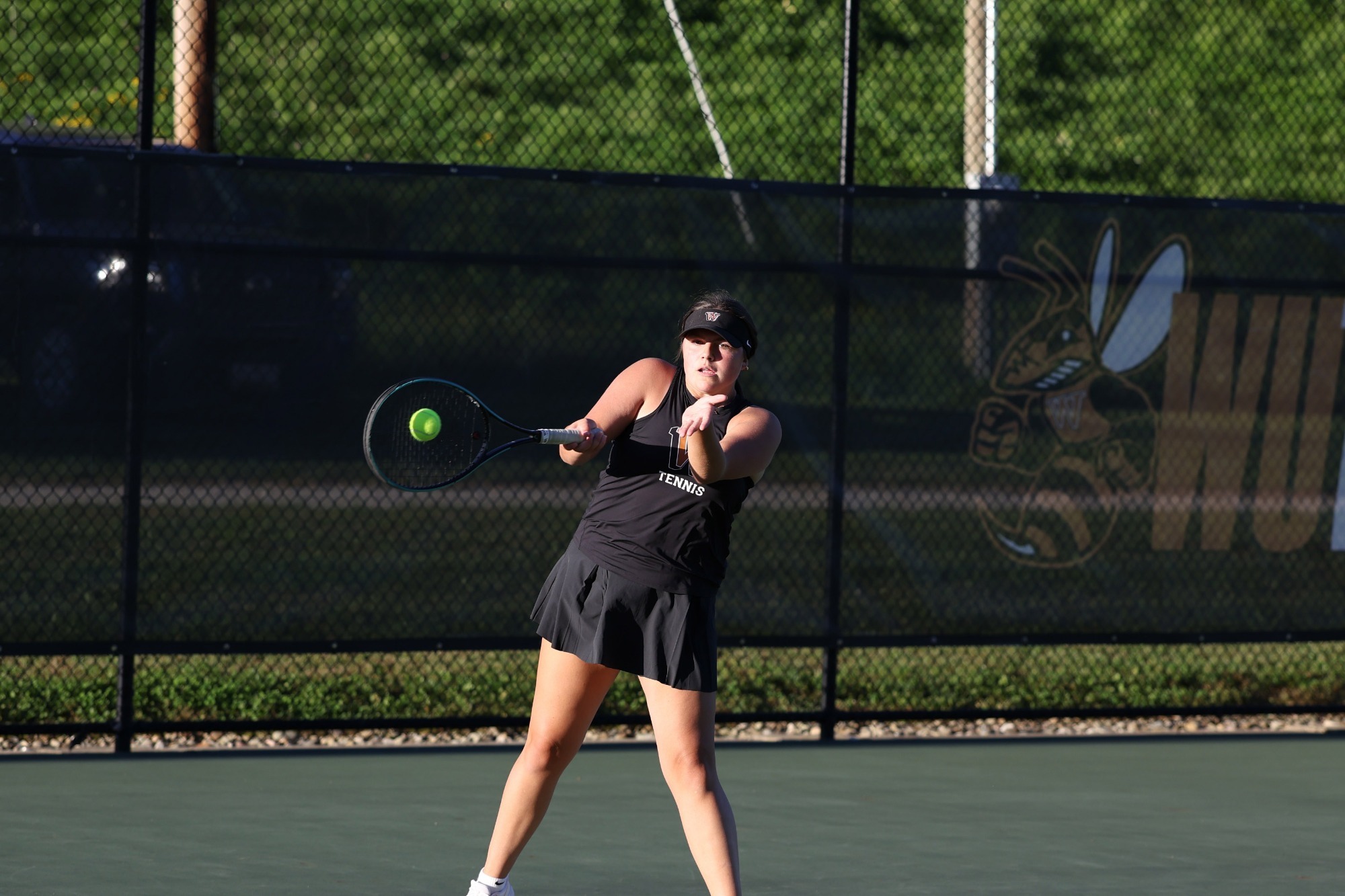 Waynesburg's Gabby Peiritsh strikes a backhanded shot on a sunny tennis court