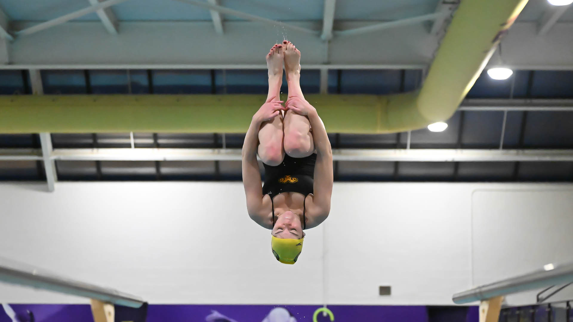 Alicia McHugh in a tuck doing a reverse dive