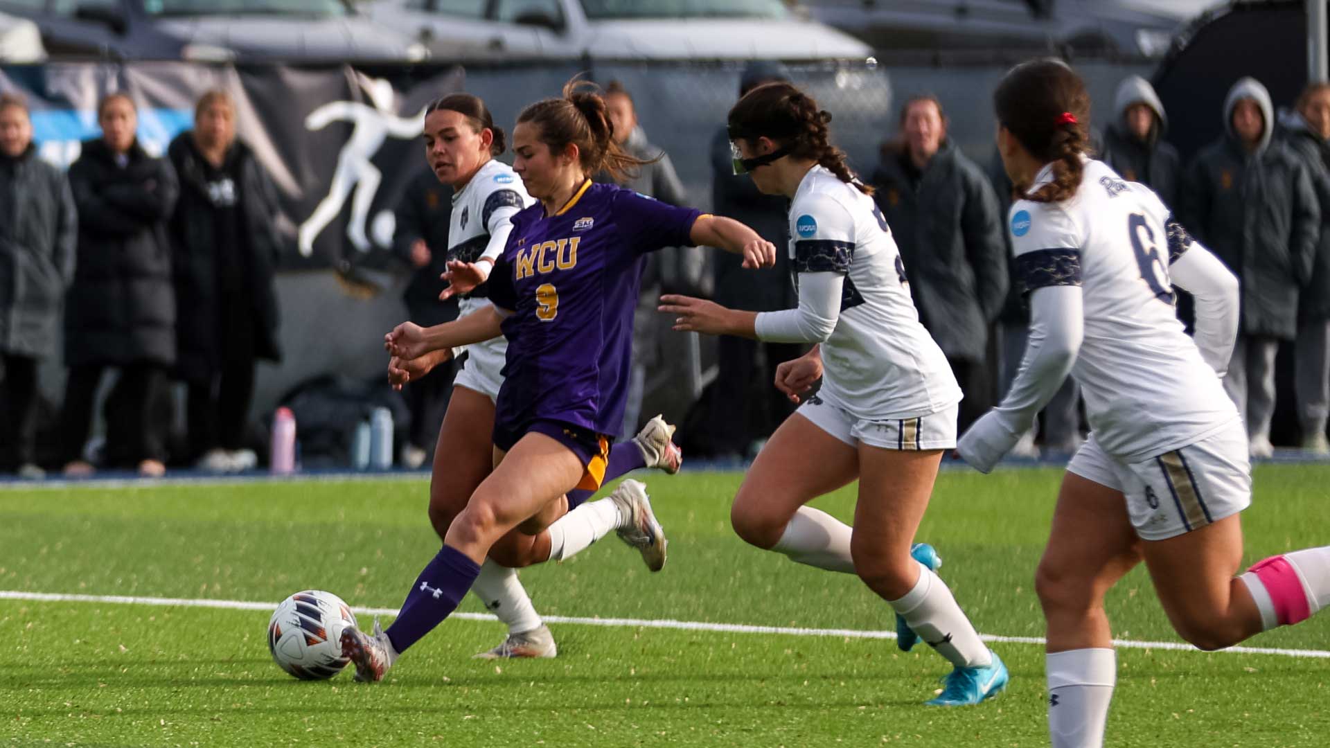 Kate Alexander Sends a cross past two Shepherd defenders at Shepherd