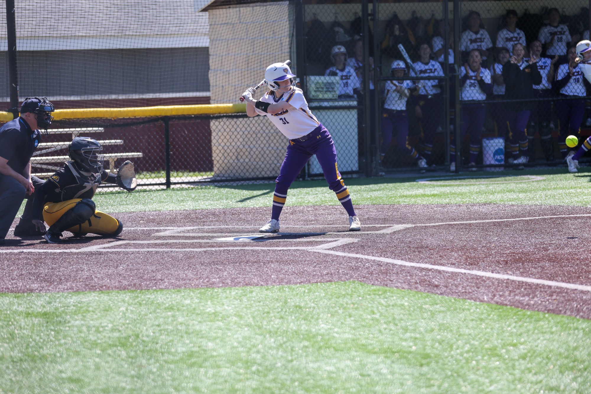 NUMBER 31 HITTING MID GAME  IN TEAM ISSUED WHITE UNIFORM AND PURPLE PANTS 