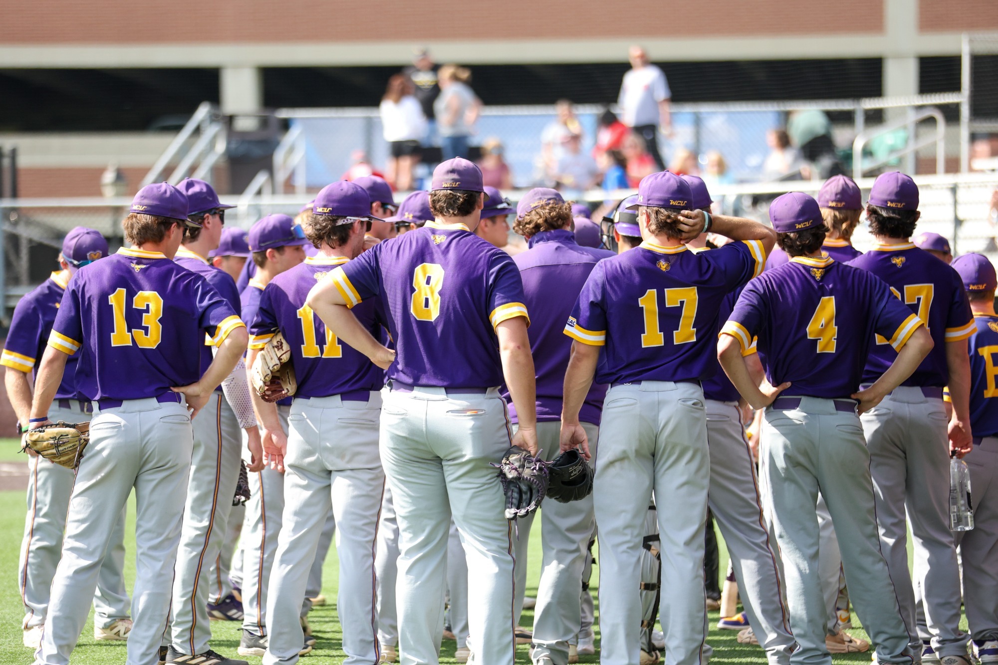 TEAM AT PENNSYLVANIA STATE ATHLETIC CONFERENCE Tournament TEAM HUDDLE ON FIELD IN TEAM ISSUED PURPLE UNIFORM AND GREY PANTS