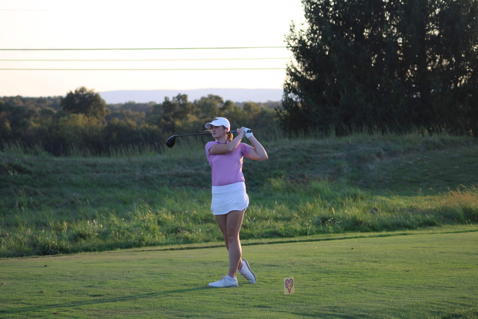 MURPHY MID SWING ON COURSE IN TEAM ISSUED WHITE HAT, PINK TOP, AND WHITE SKIRT