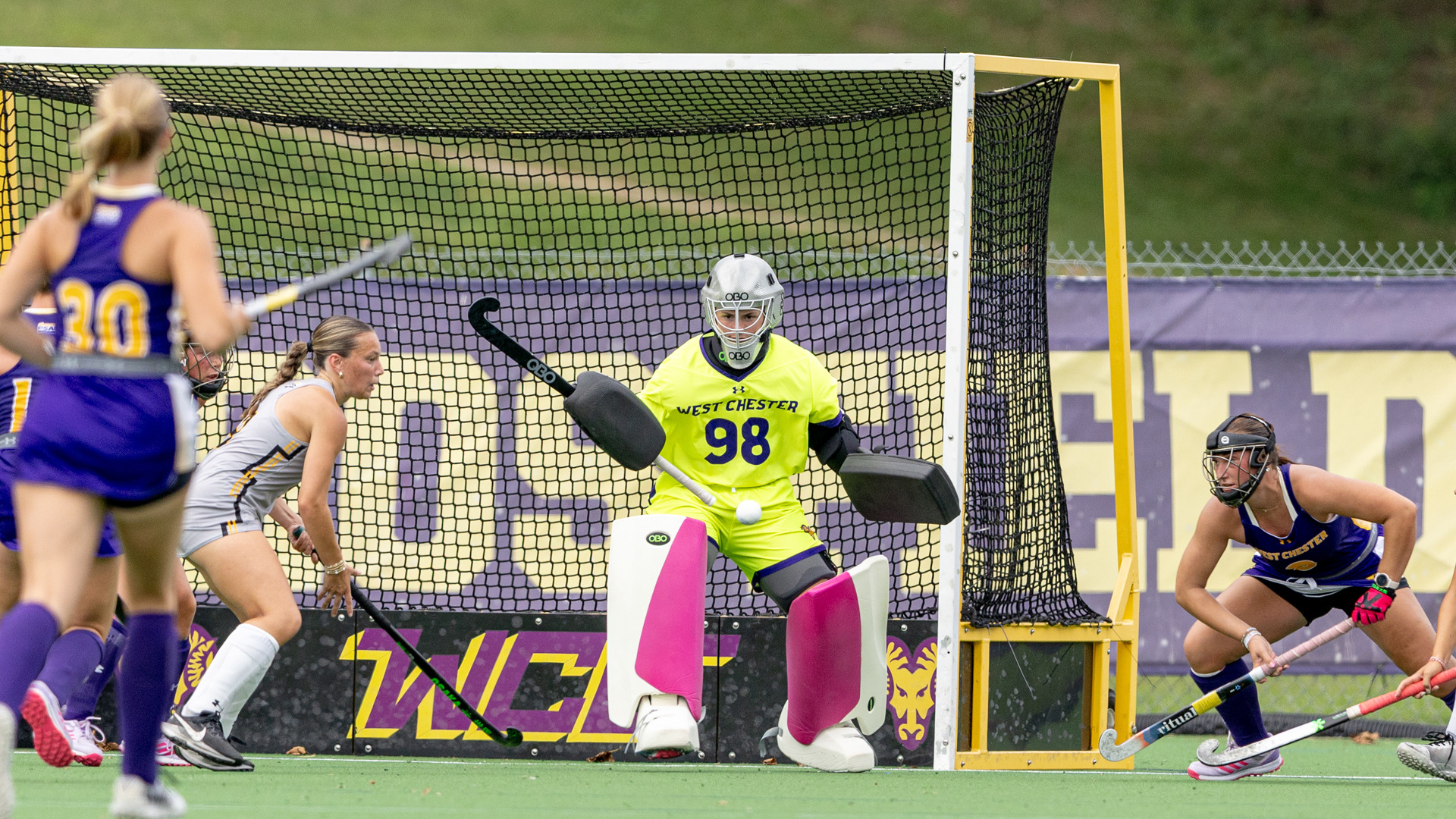 Erin O'Brien tracks the ball across the goal mouth at home in her highlight yellow uniform with white and pink goalie pads against Millersville