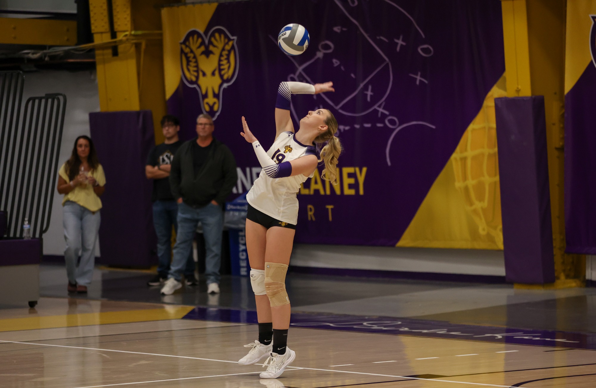 Amanda Redding serving in white short sleeve libero top on senior day in Hollinger Field House