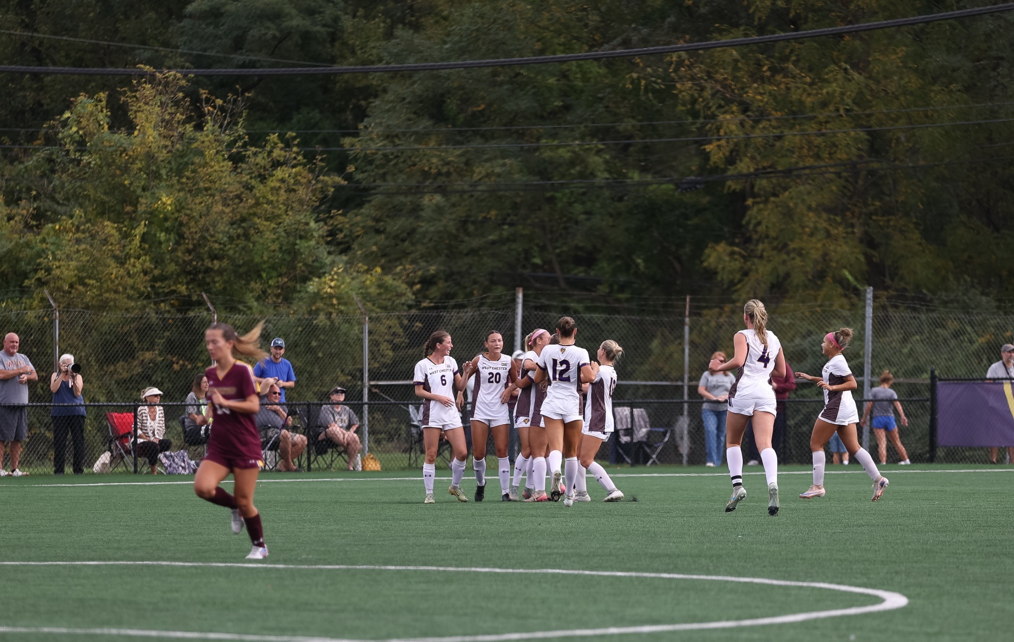 GROUP OF WOMEN'S SOCCER PLAYERS RUN TO CELEBRATE ADRIANA RYDER'S GAME-WINNING GOAL VS BLOOMBSURG ON ROCKWELL FIELD