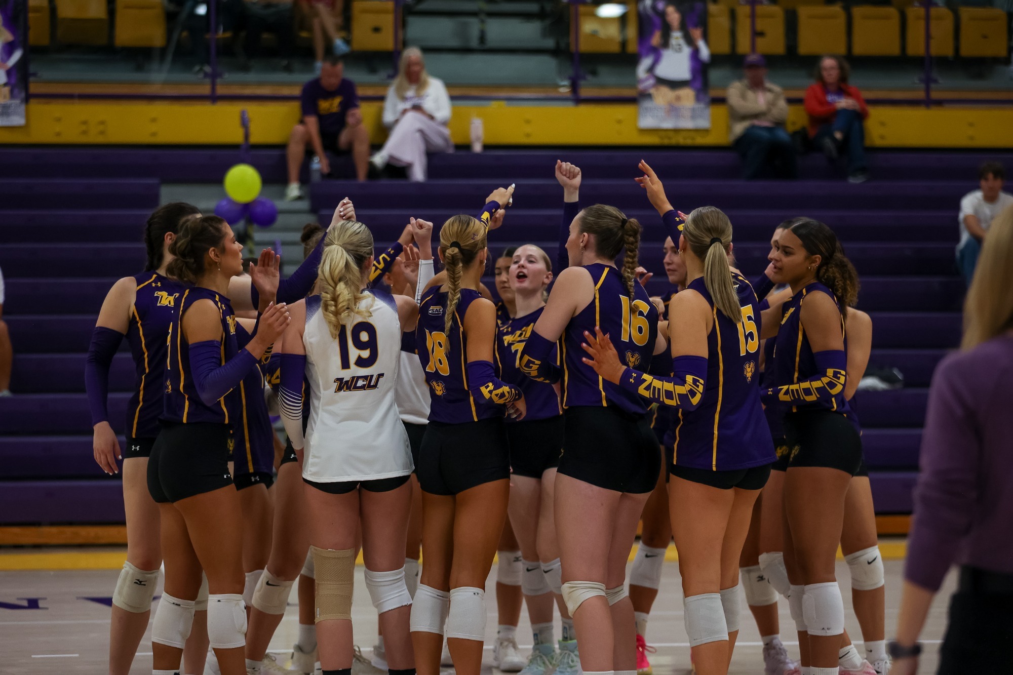WOMEN'S VOLLEYBALL WEARING PURPLE AND GOLD SLEEVELESS TOPS WITH WHITE LIBERO UNIFORMS BREAKING HUDDLE ON SENIOR DAY VS LACKAWANNA IN HOLLINGER ON OCTOBER 10
