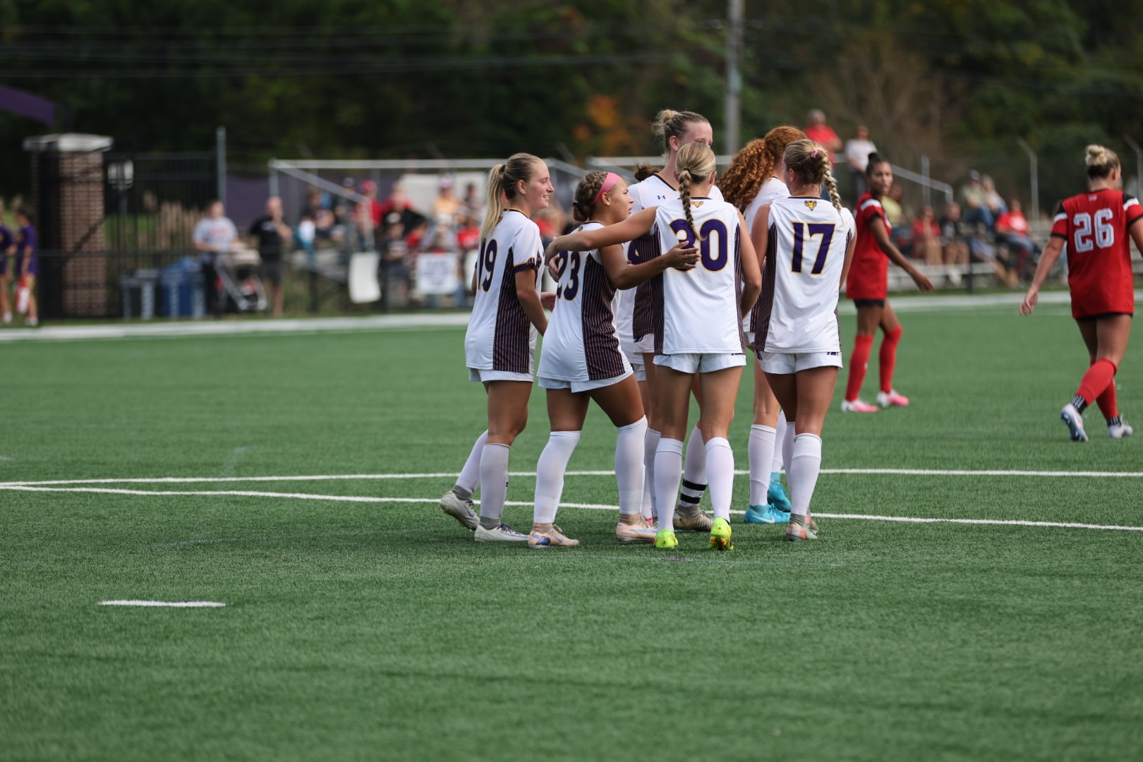 WOMEN'S SOCCER GROUP WEARING HOME WHITE UNIFORMS COMES TOGEHTER TO CELEBRATE KIANNA BARBER'S PK GOAL VS ESU ON ROCKWELL FIELD ON WEDNESDAY AFTERNOON